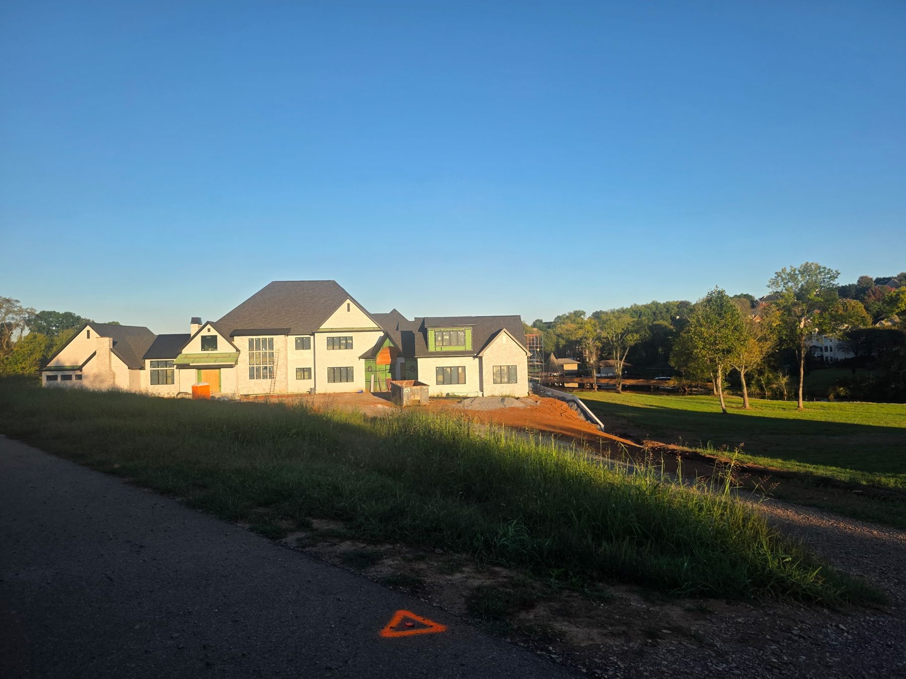 Front of the house from the street at an angle, with the lake and a boathouse to the right