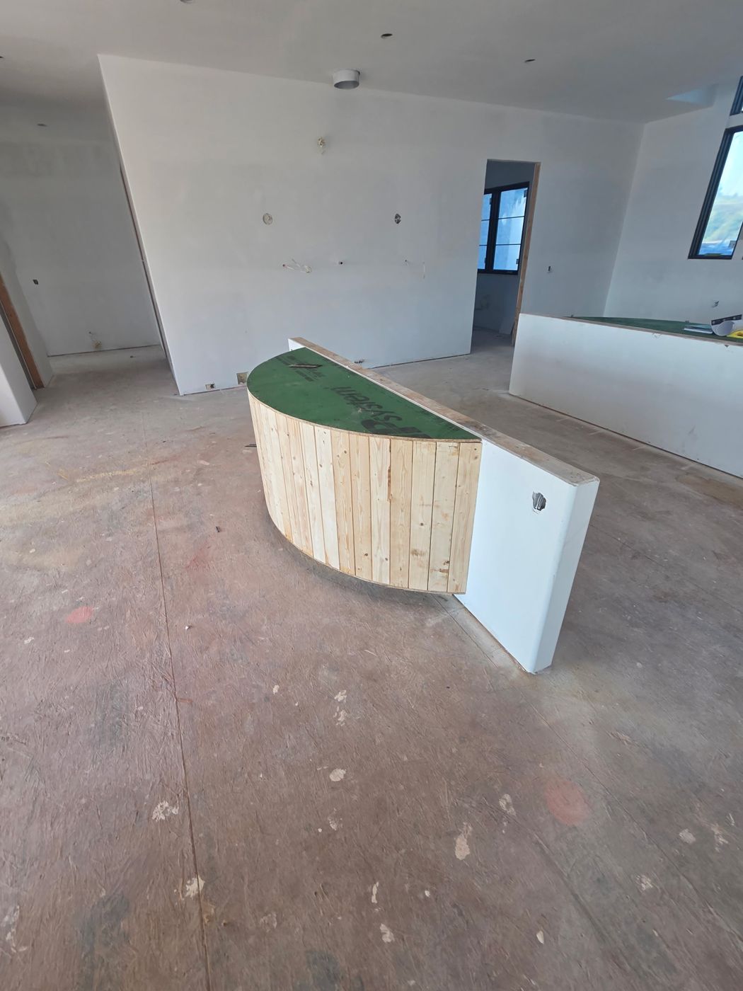 Curved kitchen island base framed with vertical boards